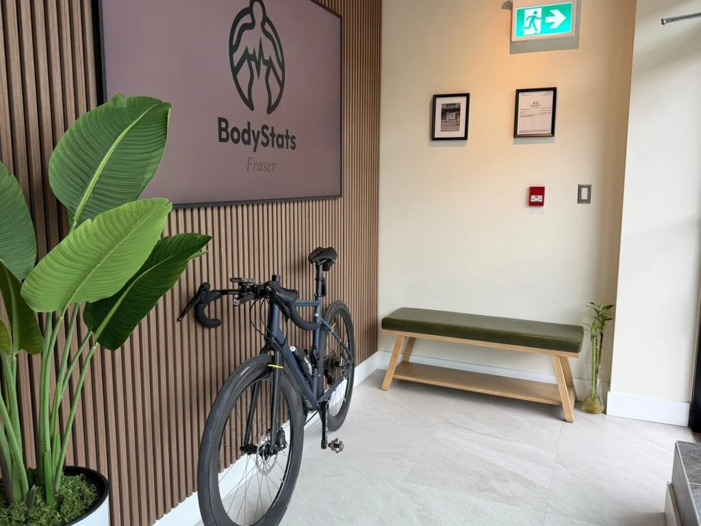 Lobby at BodyStats Fraser with the BodyStats Fraser screen, bench and road bike